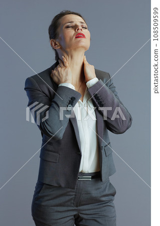 tired elegant business woman having neckpain against gray 108509599