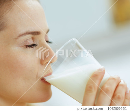 Closeup on young woman drinking milk Closeup on young woman drinking milk 108509661