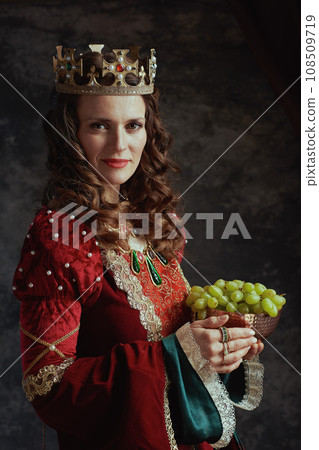 smiling medieval queen in red dress with plate of grapes smiling medieval queen in red dress with plate of grapes 108509719