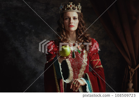 medieval queen in red dress with green apple and crown medieval queen in red dress with green apple and crown 108509723