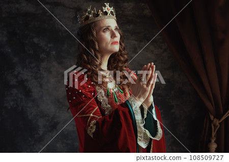 medieval queen in red dress with crown praying medieval queen in red dress with crown praying 108509727