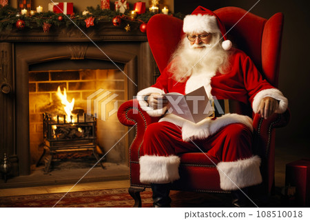 Santa Claus reading children's letters while resting in an armchair in his house Santa Claus reading children's letters while resting in an armchair in his house 108510018