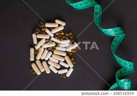 Weight Loss Pills and Measuring Tape, Diet Supplements Capsules, Obesity Lose Tablets, Color Drugs Pile 108510354