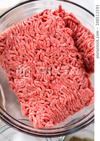 Measured ingredients in glass mixing bowls to make meatloaf. 108511591