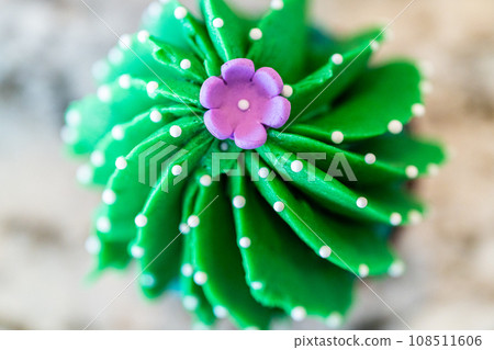 Using buttercream frosting, vanilla and chocolate cupcakes are intricately decorated to resemble various types of cactuses, creating a delightful and visually engaging dessert that showcases Using buttercream frosting, vanilla and chocolate cupcakes are intricately decorated to resemble various types of cactuses, creating a delightful and visually engaging dessert that showcases 108511606