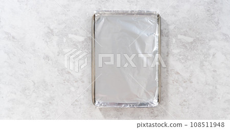 Flat lay. Lining baking sheet with cooking foil for baking. Flat lay. Lining baking sheet with cooking foil for baking. 108511948