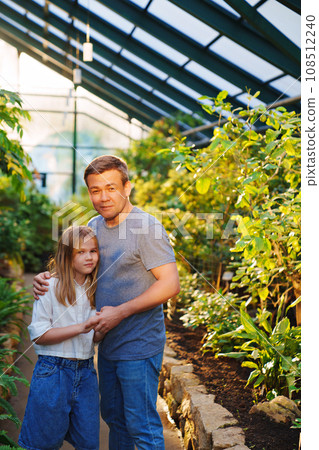 fun Dad and daughter are a teenager on a walk in the botanical garden. 108512240