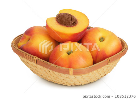 Ripe nectarine fruit with half in a wicker basket isolated on white background with full depth of field 108512376