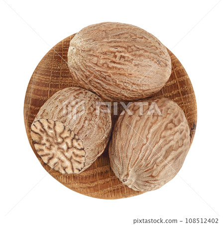 nutmeg in wooden bowl isolated on white background with full depth of field. Top view. Flat lay nutmeg in wooden bowl isolated on white background with full depth of field. Top view. Flat lay 108512402