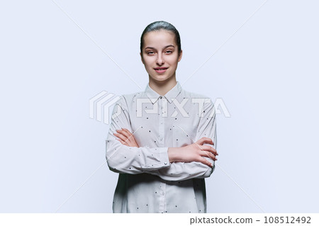 Portrait of teenage girl with crossed arms on white background Portrait of teenage girl with crossed arms on white background 108512492