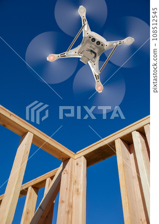 Drone Unmanned Aircraft System Flying to Inpect a House Wood Construction Framing Being Built. 108512545