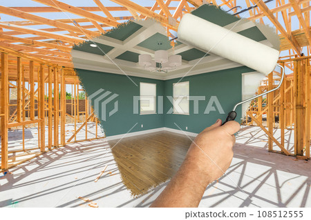 Man Using Paint Roller to Expose Finished Build of House Construction - Before and After. 108512555