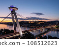The SNP bridge over the Danube river with night panorama of Bratislava with castle on the hill, Slovakia 108512623