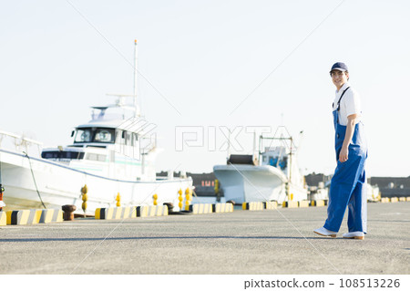 Young fishermen standing at the fishing port Young fishermen standing at the fishing port 108513226