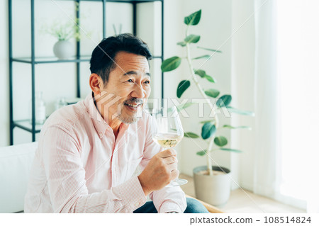 中年男子在家喝白葡萄酒 中年男子在家喝白葡萄酒 108514824