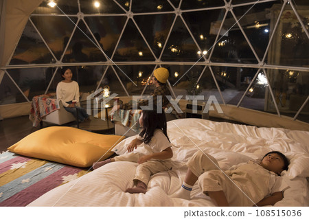 Image of a family relaxing in a guest room at a glamping facility at night Image of a family relaxing in a guest room at a glamping facility at night 108515036