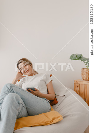 Woman sitting on beanbag and using smartphone. Woman sitting on beanbag and using smartphone. 108515189