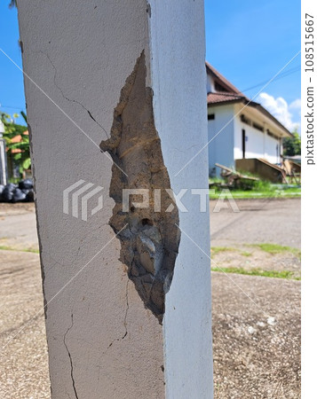 Cracks in damaged building pillars. Cracked concrete pillar of an old house. Deep and clear fractures, on the front surface of an old cement pillar. 108515667