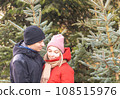 Portrait of happy woman and man hugging at Christmas Market in front of Christmas tree. 108515976