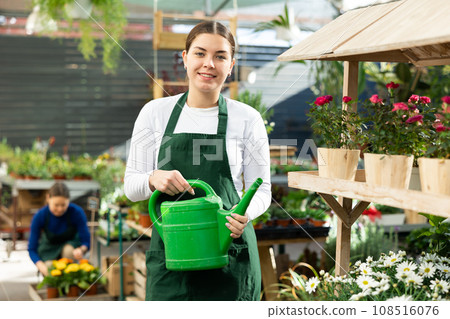 Woman seller holding watering can in flower shop 108516076