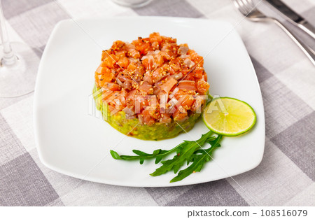 Salmon tartare with guacamole, lime slices and arugula Salmon tartare with guacamole, lime slices and arugula 108516079
