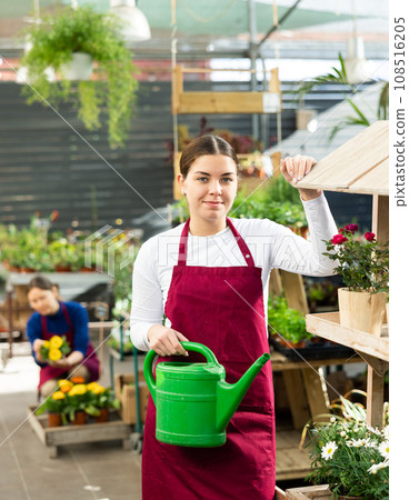 Woman seller holding watering can in flower shop 108516205