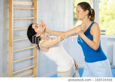 Two women training self-defense techniques in studio Two women training self-defense techniques in studio 108516308
