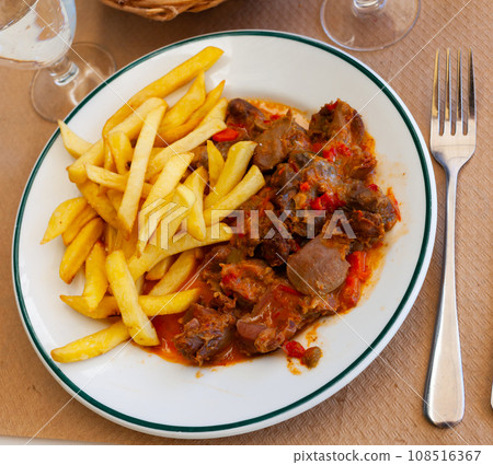 Chicken gizzards in vegetable sauce with French fries Chicken gizzards in vegetable sauce with French fries 108516367