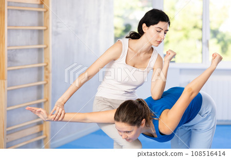 Woman is practicing self defence moves in pair with her female trainer at gym Woman is practicing self defence moves in pair with her female trainer at gym 108516414