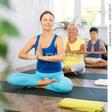 Group of people generation on mats doing yoga exercise lord of fishes pose. 108516547