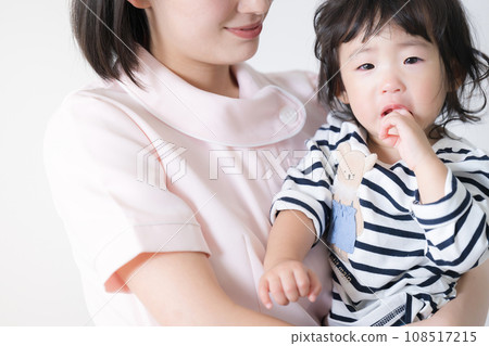 A nurse holding a baby: Checkups are difficult 108517215