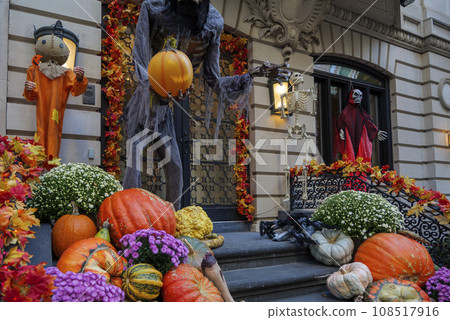 Colorful Pumpkins and Flowers on the Stairs of an Old Brownstone Home in New York City during Autumn 108517916