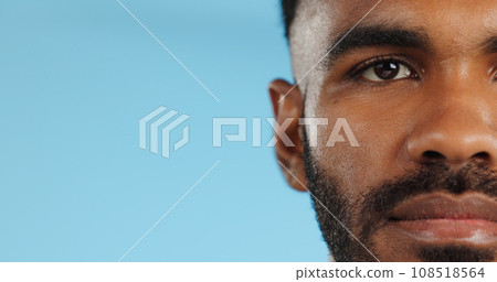 Half, face and serious black man in studio, blue background and mockup space with confidence or advertising. Portrait, closeup and marketing for skincare, wellness or healthy dermatology care 108518564