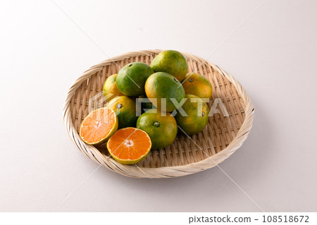 Very early mandarin oranges in basket, white background 108518672