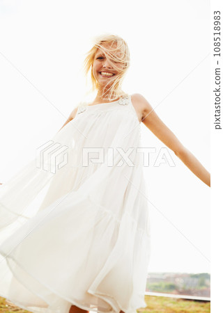 Portrait, happy woman and dress in wind outdoor on vacation, holiday or travel in summer. Freedom, smile and confident blonde person standing in nature, garden or countryside with sky in Amsterdam 108518983