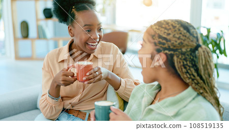 Happy, talking and women with coffee on the sofa for gossip, secret or conversation in a house. Excited, relax and a black woman with a girl or friends with communication, tea and story on the couch 108519135