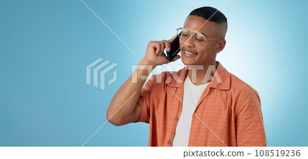 Phone call, mockup space or happy man in studio on blue background talking for communication. Modern, trendy or cool biracial model listening or calling to chat in conversation or speaking on mobile Phone call, mockup space or happy man in studio on blue background talking for communication. Modern, trendy or cool biracial model listening or calling to chat in conversation or speaking on mobile 108519236