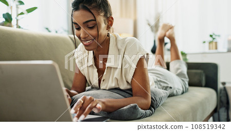 Woman, remote work and relax on sofa with laptop to update blog post, social media or digital subscription. Happy indian freelancer, lounge and computer for online shopping, elearning or typing email Woman, remote work and relax on sofa with laptop to update blog post, social media or digital subscription. Happy indian freelancer, lounge and computer for online shopping, elearning or typing email 108519342