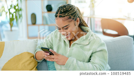 Home, smile and woman with a cellphone, internet and connection with social media, typing and network. Person, apartment and girl with a smartphone, mobile user and contact with digital app and relax 108519485