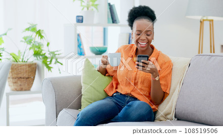 Coffee, woman and laugh with phone on sofa, reading social media post and mobile chat at home. Happy african person drinking tea, scroll multimedia connection and funny meme online with smartphone 108519506