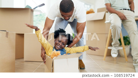 Father, playing and child in a box while moving house with a black family together in a living room. Man and a girl kid excited about fun game in their new home with a smile, happiness and energy Father, playing and child in a box while moving house with a black family together in a living room. Man and a girl kid excited about fun game in their new home with a smile, happiness and energy 108519724