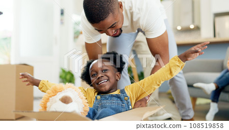 Father, playing and child in a box while moving house with a black family together in a living room. Man and a girl kid excited about fun game in their new home with a smile, happiness and energy Father, playing and child in a box while moving house with a black family together in a living room. Man and a girl kid excited about fun game in their new home with a smile, happiness and energy 108519858