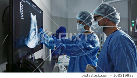 Surgery, x ray and a team of doctors in the hospital for an operation or procedure to remove a tumor. Healthcare, medical teamwork and a surgeon looking at a screen with a medicine professional Surgery, x ray and a team of doctors in the hospital for an operation or procedure to remove a tumor. Healthcare, medical teamwork and a surgeon looking at a screen with a medicine professional 108519982