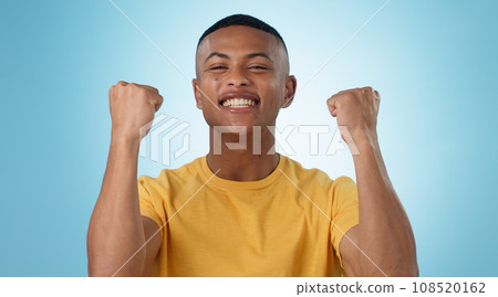 Man, portrait and excited for success with fist in studio to celebrate deal, promotion or yes to winning lottery on blue background. Happy model, giveaway prize winner or reward for bonus achievement 108520162