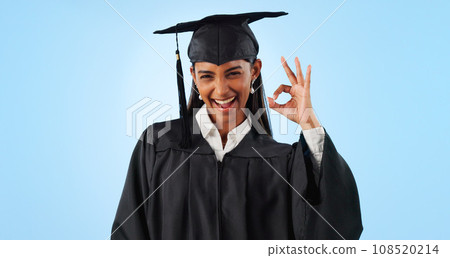 Woman, ok sign and smile for graduation in studio with review with vote, choice or support by blue background. Student girl, portrait and celebration for icon, emoji or decision for success with goal 108520214