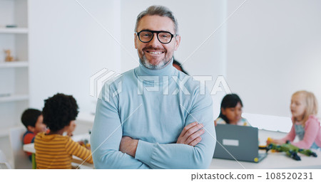Portrait, man and teacher with arms crossed, classroom and education with children, students and employee. Face, happy person and educator with kids, learning and teaching in a school and knowledge Portrait, man and teacher with arms crossed, classroom and education with children, students and employee. Face, happy person and educator with kids, learning and teaching in a school and knowledge 108520231