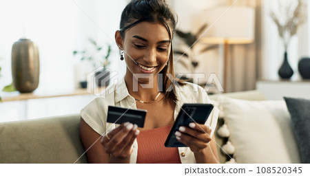 Woman, credit card and phone on sofa, smile or reading with cybersecurity, fintech app or bank info in home. Girl, smartphone and payment for password, budget or online shopping on e commerce website Woman, credit card and phone on sofa, smile or reading with cybersecurity, fintech app or bank info in home. Girl, smartphone and payment for password, budget or online shopping on e commerce website 108520345