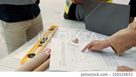 People, engineer and hands with blueprint in planning, construction or brainstorming ideas on table at site. Closeup of contract group, architect or builders with floor plan or documents on desk 108520653
