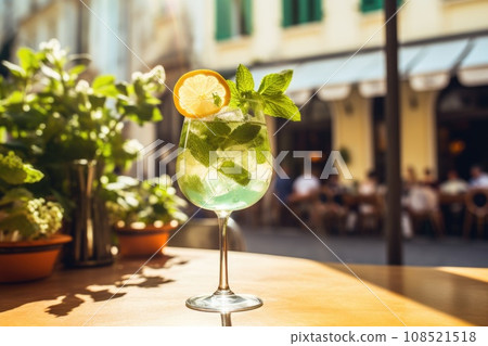 A Hugo Spritz cocktail in a glass garnished with a sprig of mint and lemon 108521518