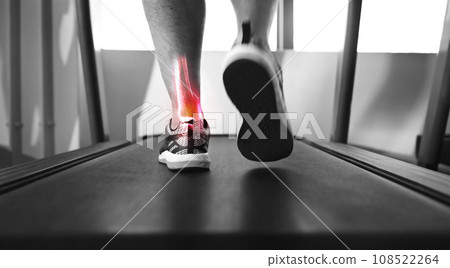 Closeup, treadmill and ankle with pain, injury and muscle tension with person walking, exercise and training. Zoom, athlete or foot with red highlight, gym equipment or strain after practice and ache Closeup, treadmill and ankle with pain, injury and muscle tension with person walking, exercise and training. Zoom, athlete or foot with red highlight, gym equipment or strain after practice and ache 108522264